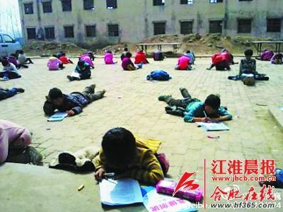 小学生趴在地上参加月考。