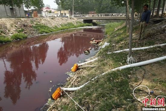 资料图： 5月3日，河南新乡西孟姜女河约2公里的河段呈现红色，被民众称为“血河”，当地采取措施将红色的河水抽到污水管网，排到污水处理厂进行处理。