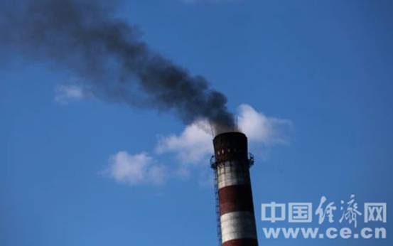 　　九联煤化烟囱中冒出的黑烟在蓝天的映衬下更加刺眼。(蒋毅坤摄)