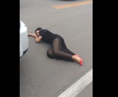 女子卧倒在车前