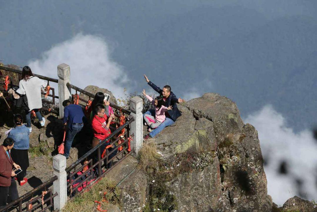 游客翻围栏拍照背后是悬崖 游客不文明行为:景区攀爬拍裸照