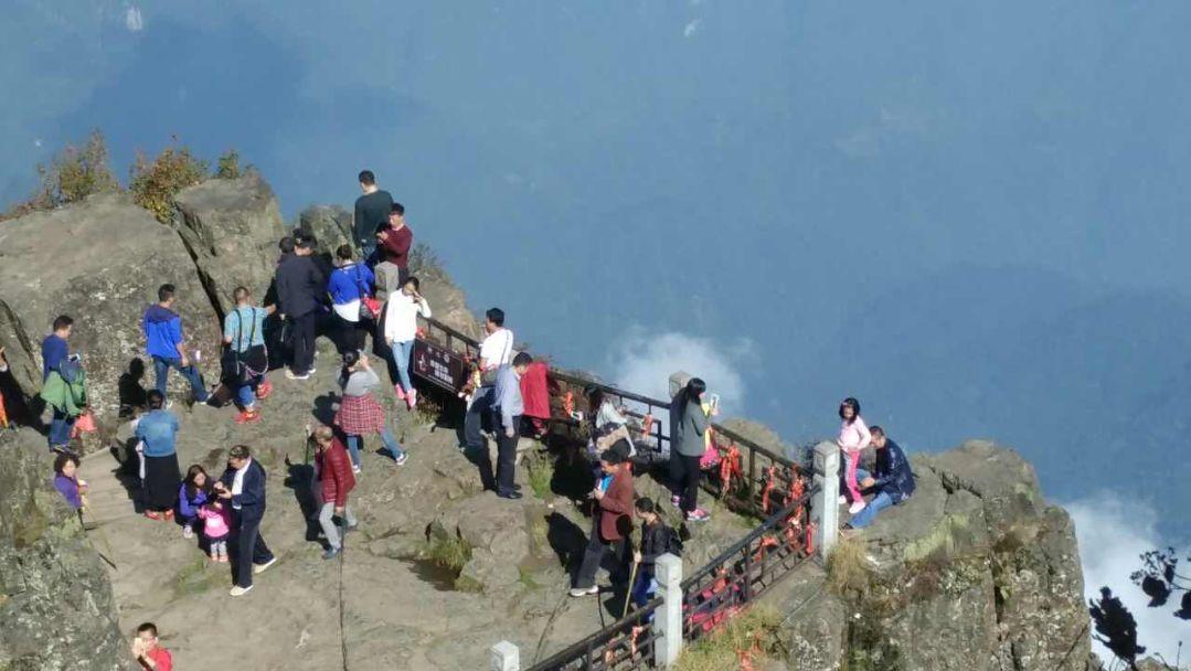 游客翻围栏拍照背后是悬崖 游客不文明行为:景区攀爬拍裸照